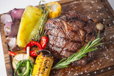 Aferin biftek ızgara Mısır, kırmızı biber, biber, soğan, sarımsak ve biberiye ahşap tahta üzerinde ile