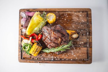 Aferin biftek ızgara Mısır, kırmızı biber, biber, soğan, sarımsak ve biberiye ahşap tahta üzerinde ile