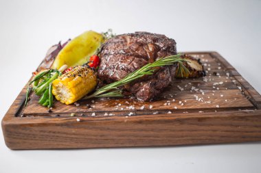 Aferin biftek ızgara Mısır, kırmızı biber, biber, soğan, sarımsak ve biberiye ahşap tahta üzerinde ile