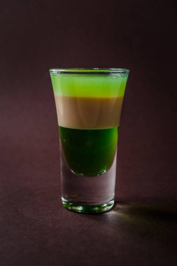 Yeşil alkollü cam ile devamsızlık vurdu, İrlanda Kreması, içki zarif koyu kahverengi zemin üzerine.