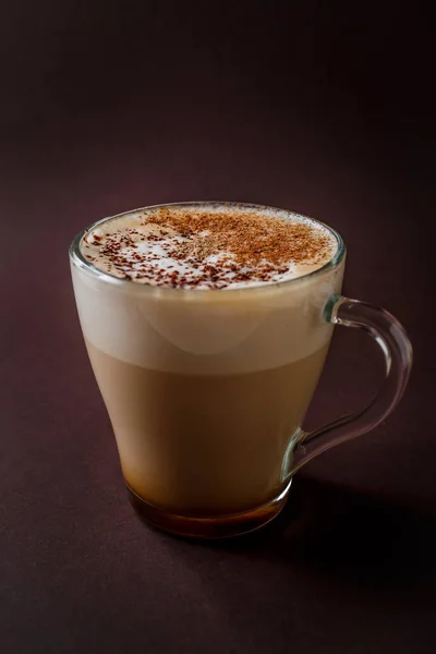 Bardak kahve zarif koyu kahverengi zemin üzerine çikolata tepesi ile.