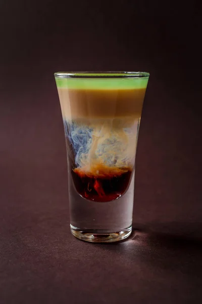 Hiroshima alcoholic shot glass with absent, sambuca, irish cream on elegant dark brown background.