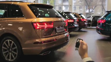 Elini tutar ve uzak tuşu yapmak için 4 araba kilidini. Dönüş sinyalleri yanıp sönüyor. Yeni arabalar. SUV. Allroad