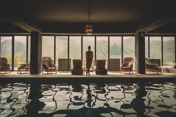 Gürcistan otel. Soğutulmuş Yüzme Havuzu manzaralı dağlara. Kız burada kalıp manzarayı bir havlu ile sarılmış.