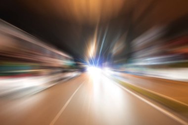 Gece trafik fütüristik hareket ile bulanıklık ve yakınlaştırma efektleri. Üzerinden yol veya sokaklar üzerinde hareket eden bir arabanın içinde ateş.