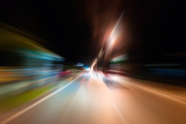 Gece trafik fütüristik hareket ile bulanıklık ve yakınlaştırma efektleri. Üzerinden yol veya sokaklar üzerinde hareket eden bir arabanın içinde ateş.