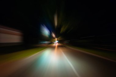 Gece trafik fütüristik hareket ile bulanıklık ve yakınlaştırma efektleri. Üzerinden yol veya sokaklar üzerinde hareket eden bir arabanın içinde ateş.