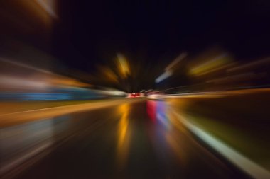 Gece trafik fütüristik hareket ile bulanıklık ve yakınlaştırma efektleri. Üzerinden yol veya sokaklar üzerinde hareket eden bir arabanın içinde ateş.