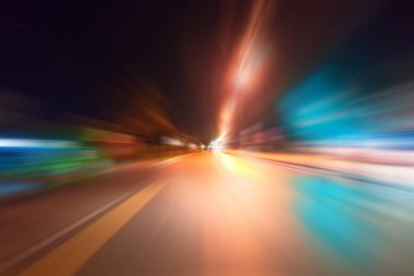 Gece trafik fütüristik hareket ile bulanıklık ve yakınlaştırma efektleri. Üzerinden yol veya sokaklar üzerinde hareket eden bir arabanın içinde ateş.