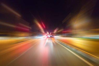 Gece trafik fütüristik hareket ile bulanıklık ve yakınlaştırma efektleri. Üzerinden yol veya sokaklar üzerinde hareket eden bir arabanın içinde ateş.
