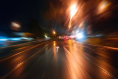 Gece trafik fütüristik hareket ile bulanıklık ve yakınlaştırma efektleri. Üzerinden yol veya sokaklar üzerinde hareket eden bir arabanın içinde ateş.