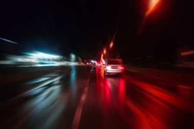 Gece trafik fütüristik hareket ile bulanıklık ve yakınlaştırma efektleri. Üzerinden yol veya sokaklar üzerinde hareket eden bir arabanın içinde ateş.