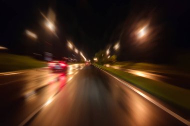Gece trafik fütüristik hareket ile bulanıklık ve yakınlaştırma efektleri. Üzerinden yol veya sokaklar üzerinde hareket eden bir arabanın içinde ateş.