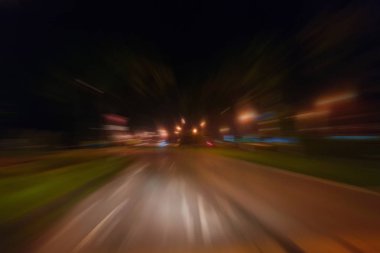 Gece trafik fütüristik hareket ile bulanıklık ve yakınlaştırma efektleri. Üzerinden yol veya sokaklar üzerinde hareket eden bir arabanın içinde ateş.
