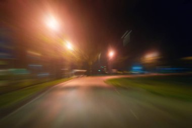 Gece trafik fütüristik hareket ile bulanıklık ve yakınlaştırma efektleri. Üzerinden yol veya sokaklar üzerinde hareket eden bir arabanın içinde ateş.