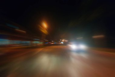 Gece trafik fütüristik hareket ile bulanıklık ve yakınlaştırma efektleri. Üzerinden yol veya sokaklar üzerinde hareket eden bir arabanın içinde ateş.