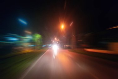 Gece trafik fütüristik hareket ile bulanıklık ve yakınlaştırma efektleri. Üzerinden yol veya sokaklar üzerinde hareket eden bir arabanın içinde ateş.