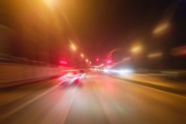 Gece trafik fütüristik hareket ile bulanıklık ve yakınlaştırma efektleri. Üzerinden yol veya sokaklar üzerinde hareket eden bir arabanın içinde ateş.