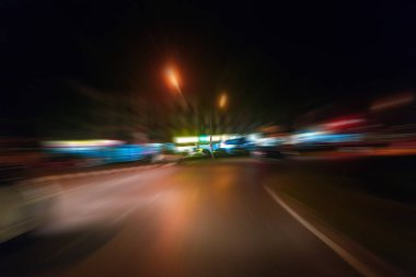 Gece trafik fütüristik hareket ile bulanıklık ve yakınlaştırma efektleri. Üzerinden yol veya sokaklar üzerinde hareket eden bir arabanın içinde ateş.