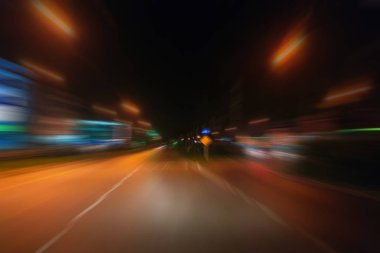 Gece trafik fütüristik hareket ile bulanıklık ve yakınlaştırma efektleri. Üzerinden yol veya sokaklar üzerinde hareket eden bir arabanın içinde ateş.