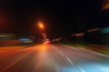 Gece trafik fütüristik hareket ile bulanıklık ve yakınlaştırma efektleri. Üzerinden yol veya sokaklar üzerinde hareket eden bir arabanın içinde ateş.