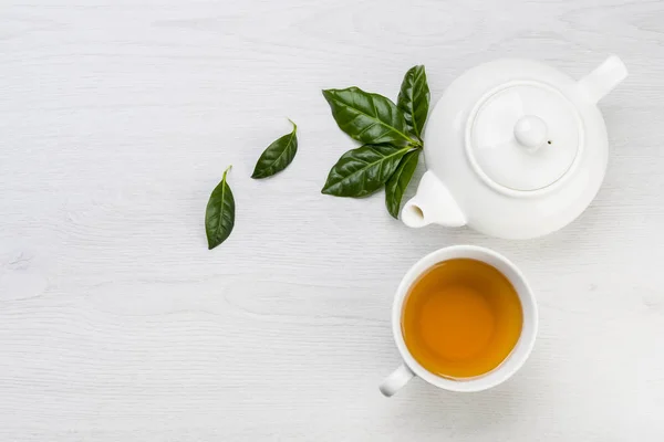 Teekanne Und Tasse Tee Mit Teeblättern Auf Dem Tisch — Stockfoto