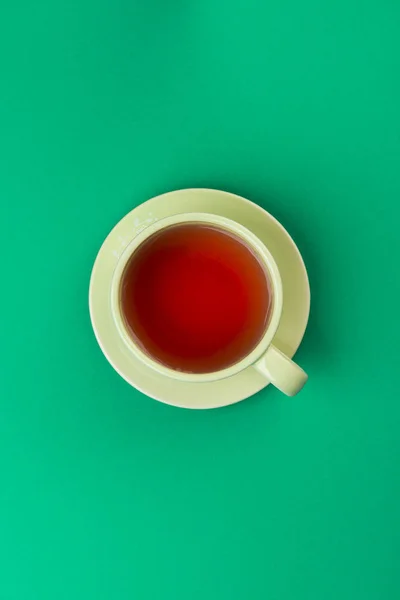 green cup of tea on green tablecloth