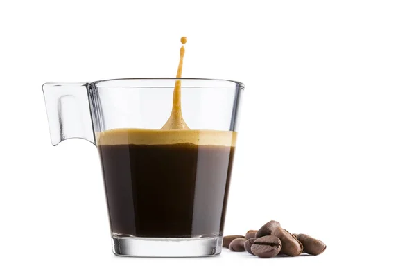 黑咖啡在玻璃杯子与咖啡豆和跳跃下落在白色背景 — 图库照片
