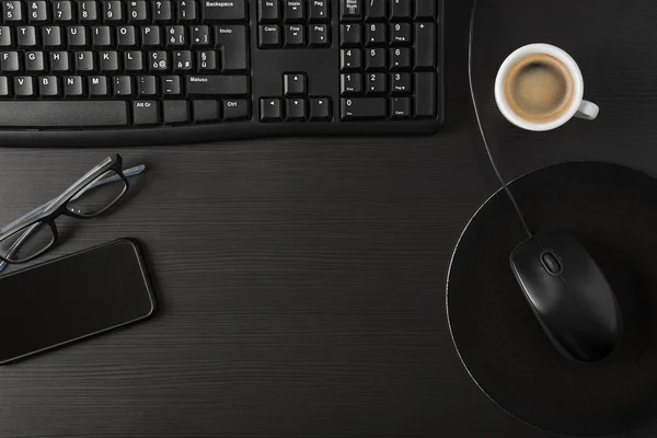 Bir Fincan Kahve Bilgisayar Kişisel Eşyalarla Dolu Toplam Siyah Masa — Stok fotoğraf