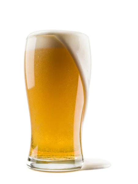 白い背景に泡が溢れるラガービールのグラスは — ストック写真