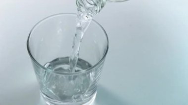 Şişeden bardağa maden suyu dökülüyor.