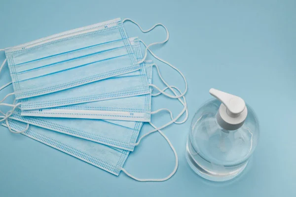 Mascarilla Protectora Quirúrgica Con Gel Antibacteriano Sobre Fondo Azul — Foto de Stock