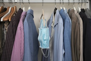 Kıyafetlerle sallanan farklı koruyucu maskeler.