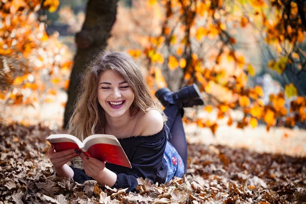 Genç Kadınlar Her Yerinde Sonbahar Yaprakları Ile Parkta Bir Kitap — Stok fotoğraf