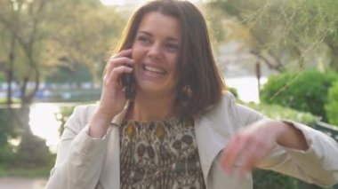 Gün batımı telefonda konuşurken, güzel mutlu kadın