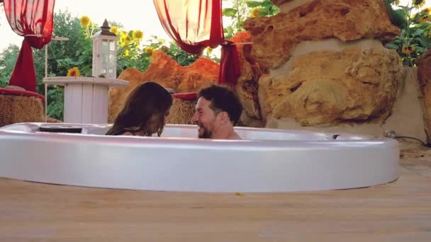 Pareja Feliz Spa Exterior Bañera Salpicando Hacia Cámara Sonriendo Feliz — Vídeo de stock