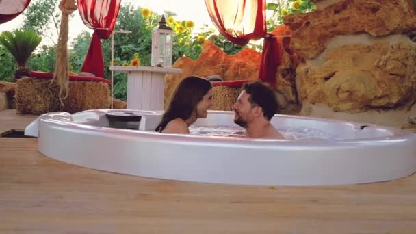 Pareja Feliz Spa Exterior Bañera Salpicando Hacia Cámara Sonriendo Feliz — Vídeos de Stock