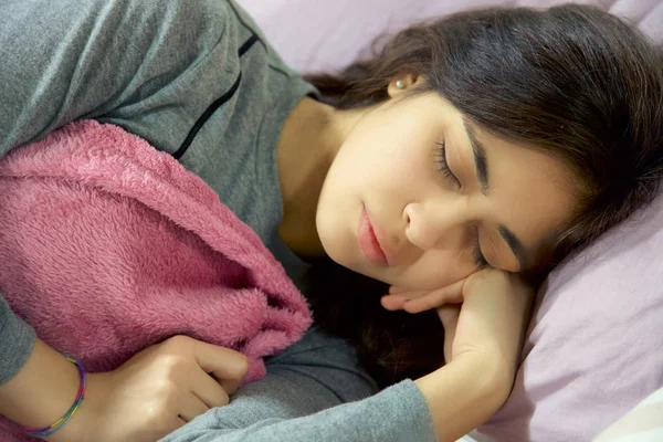 柔らかい毛布で寝ているヒスパニック系の女性 ストックフォト