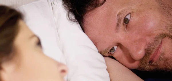 Gelukkig paar op zoek naar elkaar in bed in liefde extreme close-up — Stockfoto