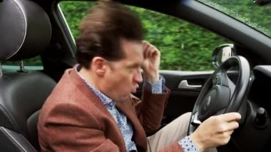 Komik iş adamı arabada dans ediyor, müzik dinliyor.