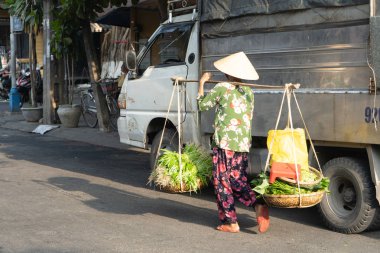 Yaşlı kadın yerel pazara sunmaktadır. Sokak satıcı Hoi an, Vietnam.