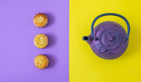 Mooncakes, teapot on duo tone background with copy space. Chinese mid-autumn festival food.