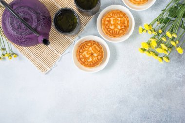 Mooncakes, çay, Çaydanlık, kasımpatı çiçekleri açık renkli kopya alanı ile. Çin sonbahar ortası festivali yemeği.