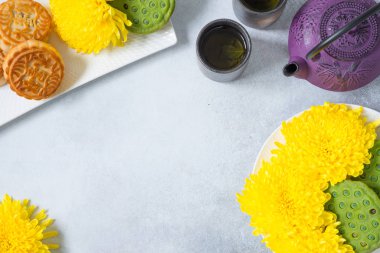Mooncakes, Çaydanlık, kasımpatı çiçekleri, lotus tohumları bakla ışık arka plan üzerinde. Çin sonbahar ortası festivali yemeği.