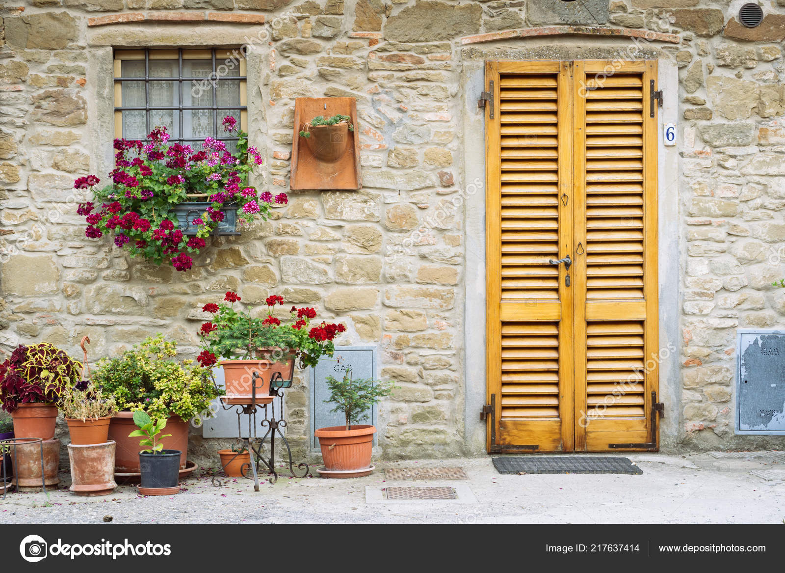 Hermosas flores frente a la pared de piedra en un pequeño pueblo de origen  medieval. Volpaia, Toscana, Italia — Foto de stock #217637414 © Llullavi, image size:1600x1167