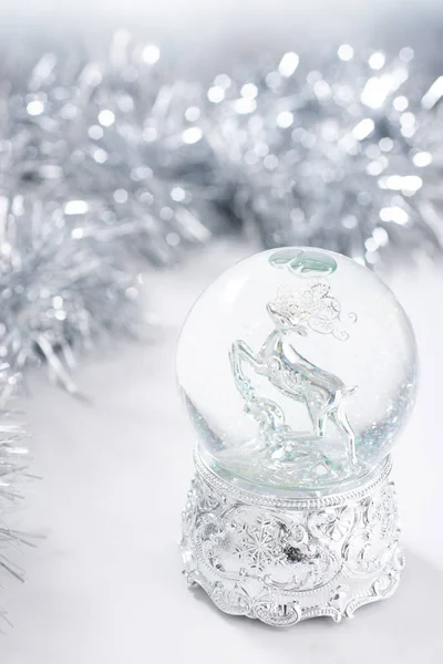 Різдвяний фон зі срібним різдвяним водяним глобусом та мішурою — стокове фото