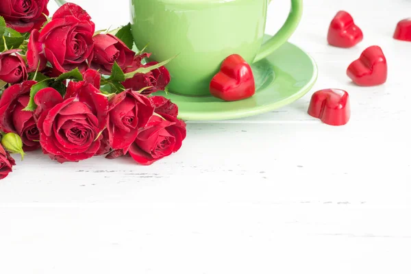 Valentines day background with tea cup, sweets and red roses. — Stock Photo, Image