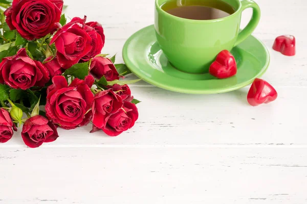 Valentines day background with tea cup, sweets and red roses. — Stock Photo, Image