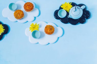 Mooncake, mavi çaydanlık, mavi arka plan üzerinde sarı krizantem çiçekleri. Çin sonbahar ortası festival gıda.