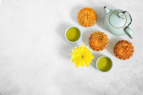 Bolos de lua, bule azul, flores de crisântemo amarelo e xícara de chá verde. Comida chinesa de meados do outono . — Fotografia de Stock